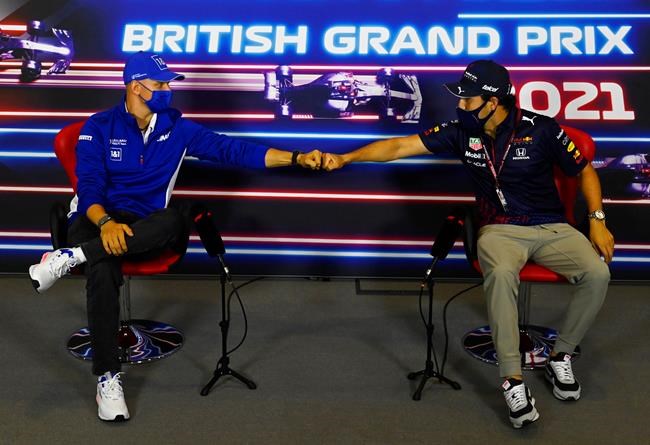 FILE - In this July 15, 2021 file photo, Haas driver Mick Schumacher of Germany, left, and Red Bull driver Sergio Perez of Mexico greet each other with a fist bump as they attend a media conference at the Silverstone circuit, Silverstone, England. As workers return to the office, friends reunite and more church services shift from Zoom to in person, this exact question is befuddling growing numbers of people: to shake or not to shake. (Mark Sutton, Pool Photo via AP, File)