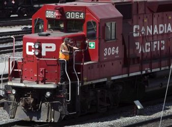  A Canadian Pacific Railway employee walks along the side of a locomotive in a marshalling yard in Calgary, Wednesday, May 16, 2012. The board of Kansas City Southern has ruled that a takeover offer from Canadian Pacific Railway Ltd. is a superior proposal to its agreement with Canadian National Railway Co. THE CANADIAN PRESS/Jeff McIntosh