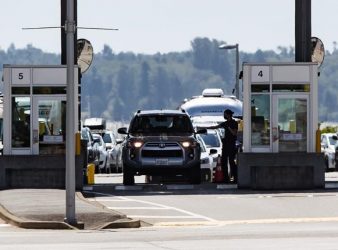 A Canada Border Services Agency officer hands documents back to a motorist entering Canada at the Douglas-Peace Arch border crossing, in Surrey, B.C., Monday, Aug. 9, 2021. The ban on non-essential land travel to the U.S. has some American companies looking for shelf space in Canada. THE CANADIAN PRESS/Darryl Dyck