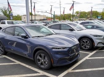 FILE - A pair of 2021 Ford Mustang Mach E are displayed for sale at a Ford dealer on Thursday, May 6, 2021, in Wexford, Pa. U.S. new vehicle sales rebounded slightly last year from 2020′s dismal numbers, but forecasters expect them to be more than 2 million below the years before the coronavirus pandemic.  (AP Photo/Keith Srakocic, File)