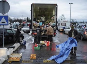 Protesters load goods into a truck part of a convoy of vehicles in Lyon, central France, Friday, Feb.11, 2022. Authorities in France and Belgium have banned road blockades threatened by groups organizing online against COVID-19 restrictions. The events are in part inspired by protesters in Canada. Citing "risks of trouble to public order," the Paris police department banned protests aimed at "blocking the capital" from Friday through Monday. (AP Photo/Laurent Cipriani)
