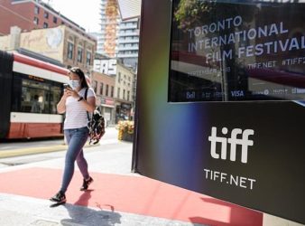 People walk past the Bell Lightbox during the 2021Toronto International Film Festival, Friday, Sept. 10, 2021. The Toronto International Film Festival says it is planning an in-person event this fall, including the return of the opening night party, networking events and awards gala.THE CANADIAN PRESS/Christopher Katsarov