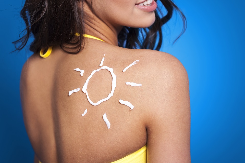 Suntan lotion on woman's arm in sun shape