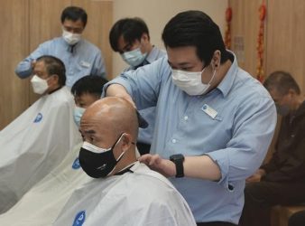 People wearing face masks get haircut at a salon after temporarily closing in Hong Kong, Thursday, March 10, 2022. (AP Photo/Vincent Yu)