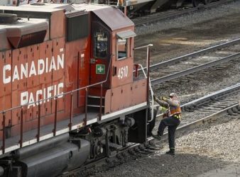An employee boards a Canadian Pacific Railway locomotive at a yard in Calgary, Alta., Friday, March 18, 2022. A spokesman for Teamsters Canada Rail Conference says the union is expecting to be back at the bargaining table with a mediator today after a labour dispute with CP Rail led a work stoppage late Saturday.THE CANADIAN PRESS/Jeff McIntosh