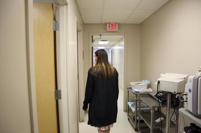 Chief Nurse Executive Danielle Maness walks through the empty hallway of the Women's Health Center of West Virginia in Charleston, W.Va. on Wednesday, June 29, 2022. The only abortion provider in the state had to immediately suspend abortion services following the U.S. Supreme Court's decision to overturn Roe v. Wade. West Virginia has an 1800s-era abortion ban on the books that makes providing abortions a felony. (AP Photo/Leah Willingham)